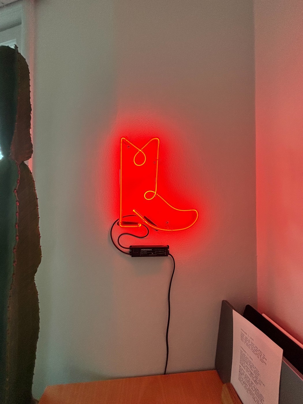 Neon cowboy boot sign glowing red