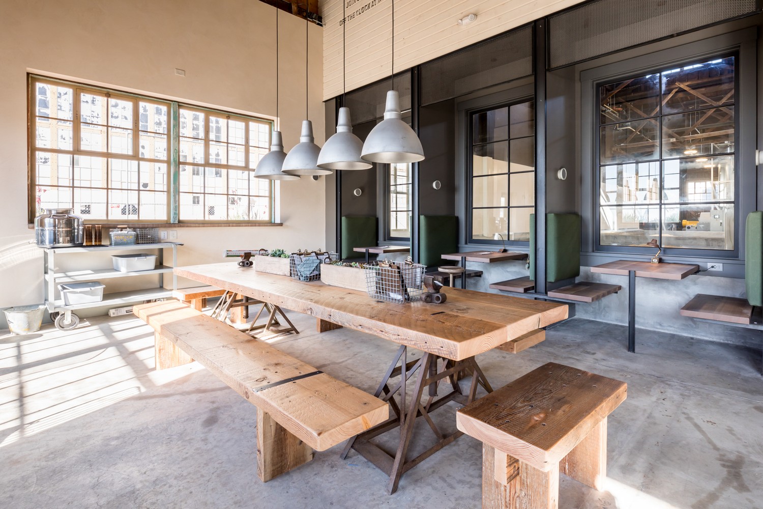 Communal table and booth seating in a warm industrial interior